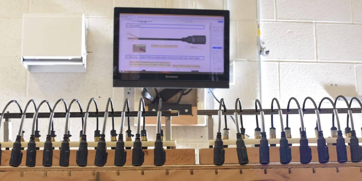 An engineer testing a product for defense standards, using equipment in a manufacturing facility